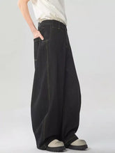 Men’s washed wide leg jeans in black denim with contrasting light stitching showcasing a wide leg fit