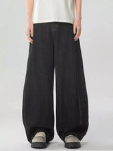 Men’s washed wide leg jeans in black denim with a relaxed loose fit and visible stitching along the seams