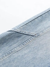 Blue denim fabric with visible stitching and worn texture of men’s washed wide leg jeans leg jeans material