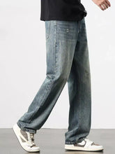 Men’s washed blue denim wide leg jeans with relaxed straight-leg cut and subtle distressed details