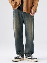 Men’s washed wide leg jeans in dark-wash denim with a faded distressed look and straight-leg cut
