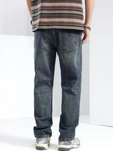 Men’s washed wide leg jeans in dark-wash denim with faded, distressed look and classic five-pocket design