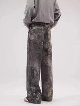 Men’s washed wide-leg jeans in distressed mottled gray and green camouflage denim with a wide-leg fit