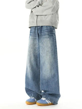 Men’s washed wide leg jeans in faded blue denim with subtle whiskering and frayed hems