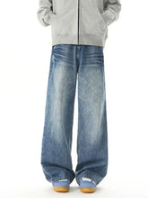 Men’s washed wide leg jeans in faded blue denim with subtle whiskering and frayed hems