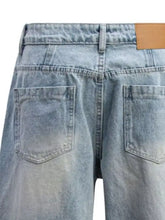 Men’s washed wide leg jeans in light-wash denim with faded texture and tan leather brand patch on the back waistband