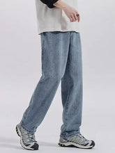 Men’s washed wide leg jeans in light wash denim with a relaxed straight-leg cut and visible stitching details