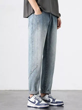 Men’s light-wash denim wide leg jeans with a relaxed tapered fit and subtle diagonal stitching details