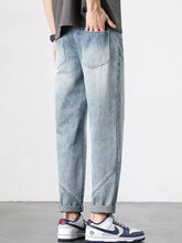 Men’s light-wash wide leg jeans with relaxed tapered fit and rolled cuffs in denim material