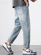Men’s light-wash denim wide leg jeans with a relaxed tapered fit and rolled cuffs in a casual style