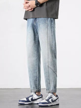 Men’s light-wash denim wide leg jeans with a relaxed tapered fit and subtle fading in a casual style