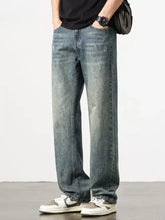 Men’s washed blue denim wide leg jeans with relaxed straight leg cut and subtle distressed details