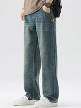 Men’s washed wide leg relaxed fit jeans in blue denim with subtle fading for a casual modern look