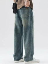 Men’s washed wide leg relaxed fit jeans in faded blue denim with subtle distressing and classic back pocket design back view