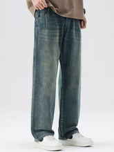 Men’s washed wide leg relaxed fit jeans in faded indigo denim with subtle whiskering and distressing details