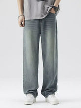 Men’s washed wide leg relaxed fit jeans in faded medium-wash blue denim with subtle whiskering and frayed hems
