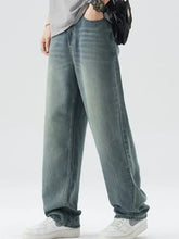 Men’s washed wide leg relaxed fit jeans in faded blue denim with visible stitching and a straight cut silhouette