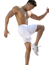 Muscular man in white mens drawstring active shorts and sneakers