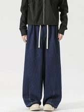 Dark blue wide leg denim drawstring jeans featuring white drawstrings for a comfortable fit in menswear