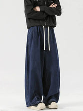 Men’s dark blue denim wide leg drawstring jeans featuring white drawstrings and a relaxed wide leg cut