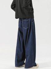 Dark blue denim men’s wide leg drawstring jeans shown from the back with relaxed cut and visible stitching on pockets