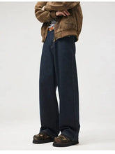 Men’s wide leg jeans in dark indigo denim with a relaxed fit and visible stitching detail