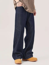 Men’s dark indigo wide leg jeans in denim with a relaxed cut and visible stitching details