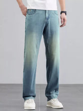 Men’s wide leg jeans in light-wash denim with a faded gradient effect transitioning from blue to green along the legs