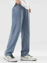 Men’s wide leg jeans in light-wash denim with a relaxed straight-leg cut and visible stitching along the seams