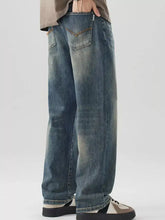 Men’s washed blue denim jeans with a relaxed wide-leg cut and visible stitching details