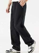 Black tapered cargo pants with chain detail and buttoned cuffs as part of men’s wide leg jeans collection