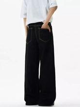 Men’s wide leg jeans in black denim with contrasting white stitching and a relaxed straight-cut silhouette