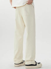 Men’s cream-colored wide leg jeans made of cotton with a relaxed fit, drawstring waistband, and two front pockets