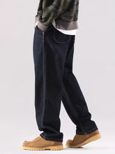 Men’s wide leg jeans in dark indigo denim with contrasting light stitching and a relaxed straight-leg cut