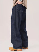 Men’s dark indigo wide leg jeans with relaxed fit and visible stitching details in denim material