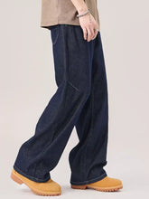 Dark indigo denim men’s wide leg jeans with a relaxed fit and visible stitching details