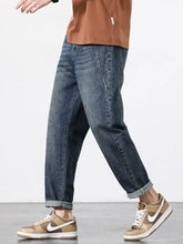 Men’s dark-wash denim wide leg jeans with a relaxed straight-leg cut and cuffed hems