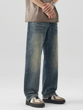 Men’s wide leg jeans in faded blue wash denim with subtle distressing and a straight-cut silhouette