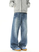 Men wide leg jeans in faded medium-blue denim with subtle whiskering and frayed hems for casual wear