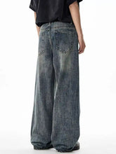 Men’s wide leg jeans in faded blue denim with subtle distressing and a relaxed fit for casual wear