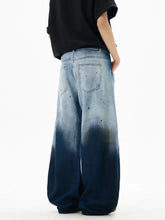 Men’s wide leg denim jeans with gradient fade from light blue to dark indigo featuring subtle distressing and back pockets