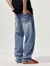 Back side of men’s wide leg light-wash denim jeans with relaxed fit and classic back pockets featuring red stitching accents