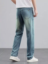 Men’s wide leg light-wash denim jeans with a relaxed fit and subtle fading along the thighs