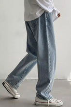Men’s wide leg jeans in light-wash denim with a relaxed fit and frayed hems for casual wear