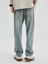 Men’s light-wash denim wide leg jeans with a relaxed straight-leg cut and classic back pockets shown from the back side