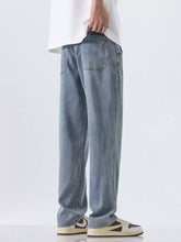 Men’s wide leg jeans in light-wash denim with a relaxed straight-leg cut and subtle fading for a modern casual look