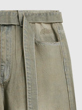 Olive green men’s wide leg denim jeans with subtle distressed texture and contrasting stitching