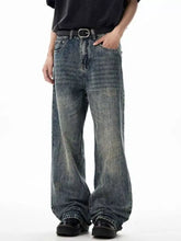 Washed blue denim men’s wide leg jeans featuring a wide leg cut and distressed patches