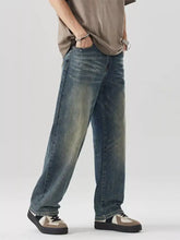 Washed blue denim men’s wide leg jeans with a relaxed straight-leg cut and faded distressing along the thighs