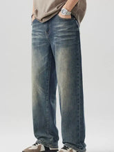 Men’s wide leg jeans in washed blue denim with relaxed straight-leg cut and faded distressing on front side